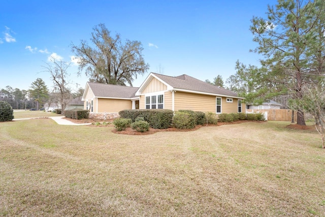 view of home's exterior featuring board and batten siding, a lawn, and fence