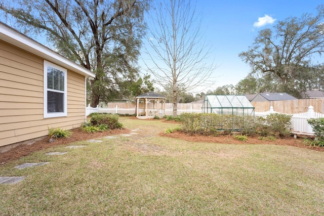 view of yard featuring a fenced backyard, a greenhouse, an outdoor structure, and a gazebo