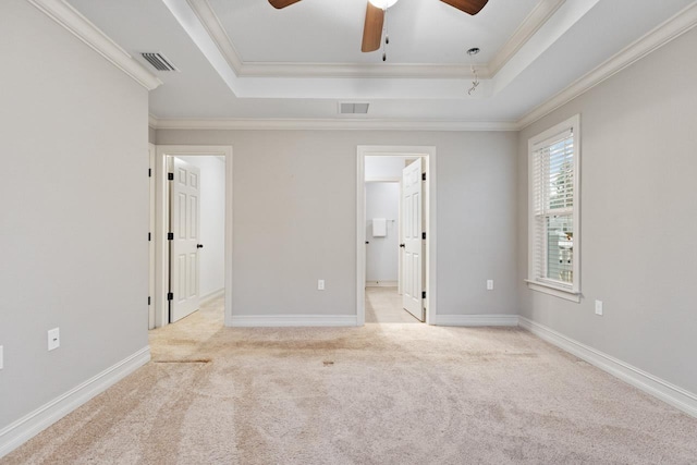 unfurnished bedroom featuring light carpet, visible vents, a raised ceiling, and crown molding