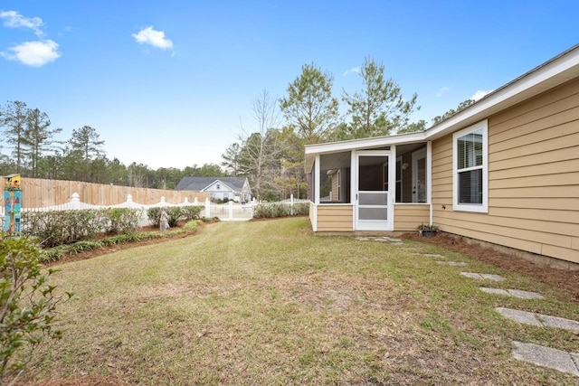 view of yard featuring a sunroom and a fenced backyard