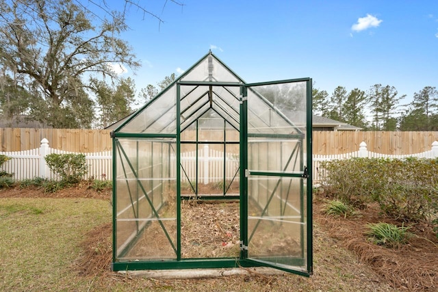 view of greenhouse with a fenced backyard