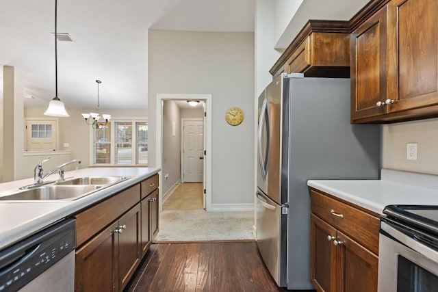 kitchen featuring visible vents, decorative light fixtures, stainless steel appliances, light countertops, and a sink