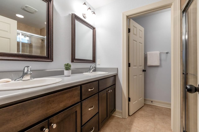 full bath featuring double vanity, visible vents, a sink, and tile patterned floors