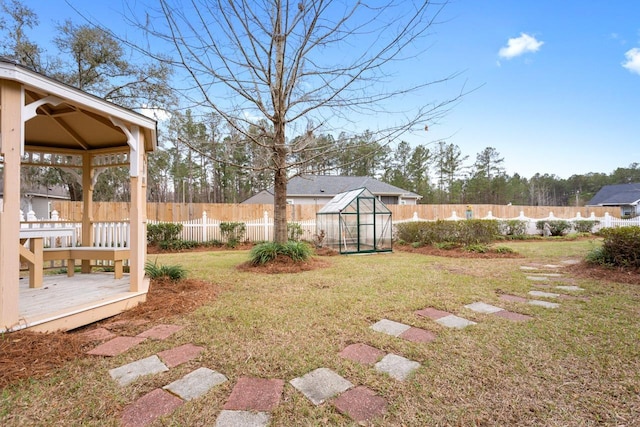 view of yard with a deck, an exterior structure, an outdoor structure, and a fenced backyard