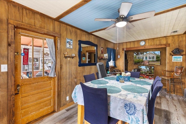 514 N Calhoun St, Perry, FL 32347 - dining area with wood walls, wood finished floors, a ceiling fan, and plenty of natural light