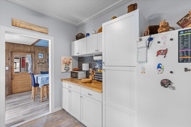 514 N Calhoun St, Perry, FL 32347 - kitchen with backsplash, white cabinets, and wooden walls