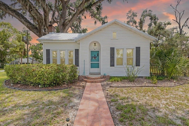 514 N Calhoun St, Perry, FL 32347 - bungalow with a chimney, a metal roof, and a yard