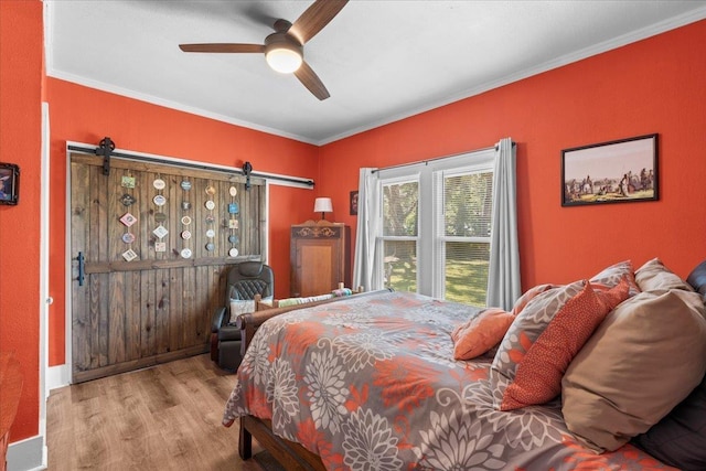 514 N Calhoun St, Perry, FL 32347 - bedroom featuring a barn door, wood finished floors, crown molding, and ceiling fan