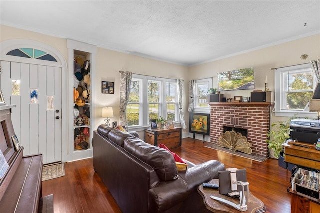 514 N Calhoun St, Perry, FL 32347 - living room featuring a brick fireplace, wood finished floors, a textured ceiling, and crown molding