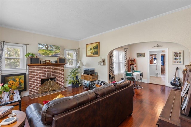 514 N Calhoun St, Perry, FL 32347 - living area featuring arched walkways, wood finished floors, crown molding, and healthy amount of natural light