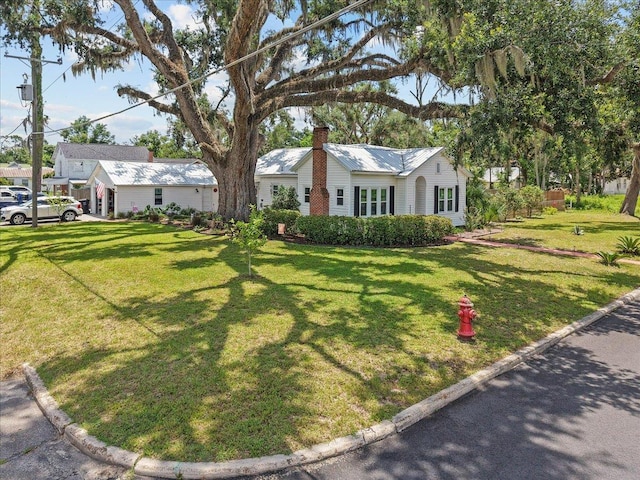 514 N Calhoun St, Perry, FL 32347 - view of front of home featuring a chimney, a front lawn, and a metal roof