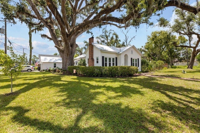 514 N Calhoun St, Perry, FL 32347 - view of property exterior featuring a chimney and a yard