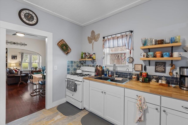 514 N Calhoun St, Perry, FL 32347 - kitchen featuring white gas range oven, open shelves, light wood-type flooring, and butcher block counters