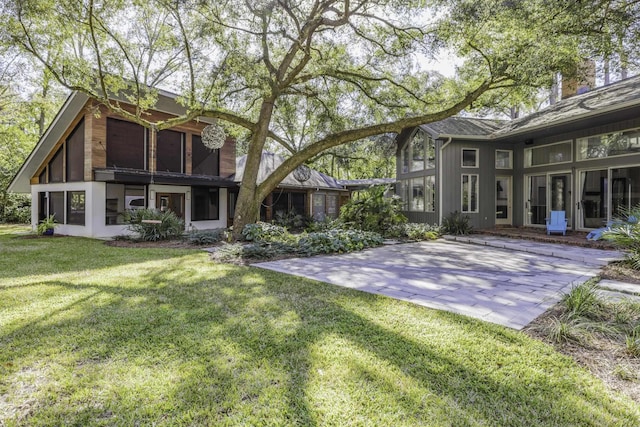 back of property with a patio and a yard