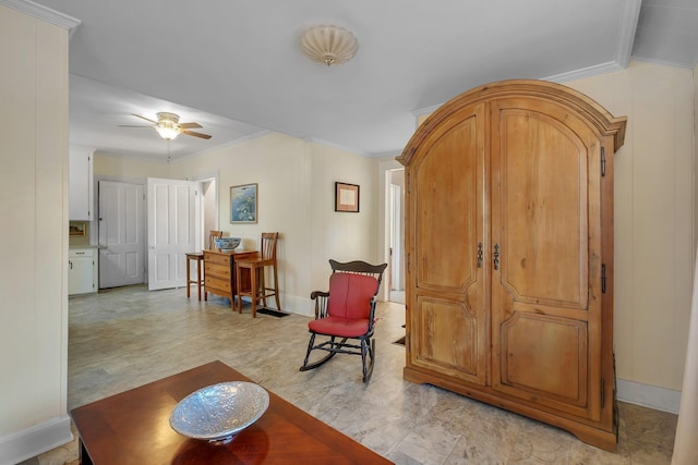 sitting room with ceiling fan and crown molding