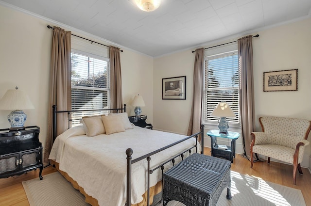 bedroom featuring crown molding and light hardwood / wood-style floors