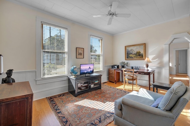 living room featuring light wood-type flooring, ceiling fan, and crown molding