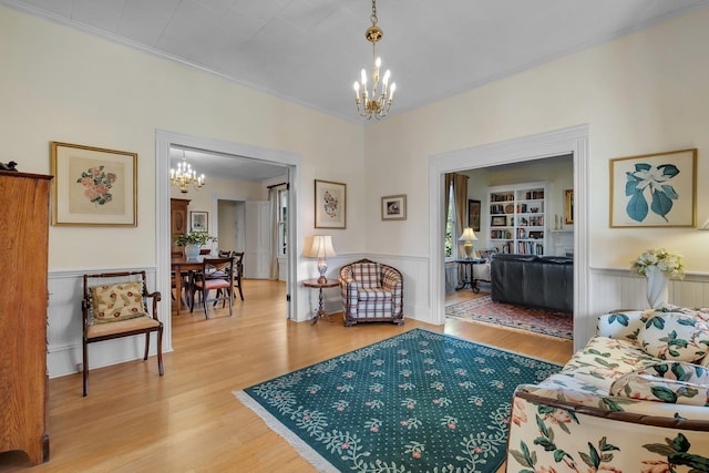 living room with a chandelier, ornamental molding, and hardwood / wood-style floors