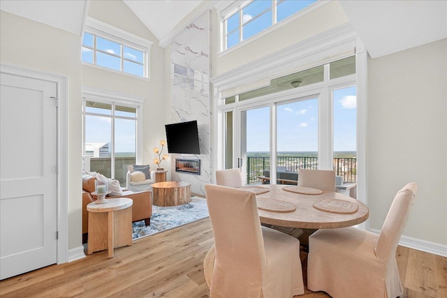 300 S Duval St Unit 2209, Tallahassee, FL 32301 - dining area featuring high vaulted ceiling, healthy amount of natural light, light wood-type flooring, and a fireplace