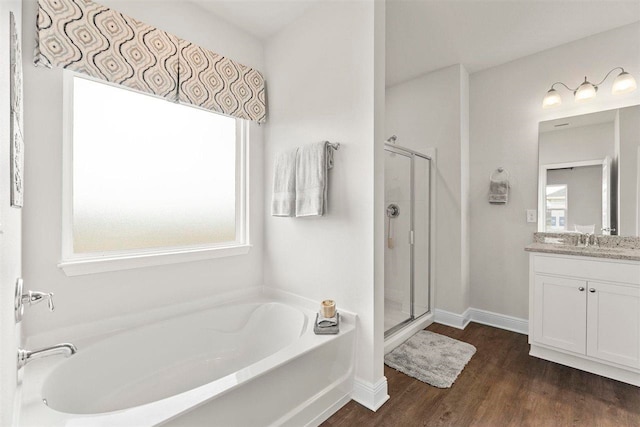 bathroom with hardwood / wood-style floors, vanity, and independent shower and bath