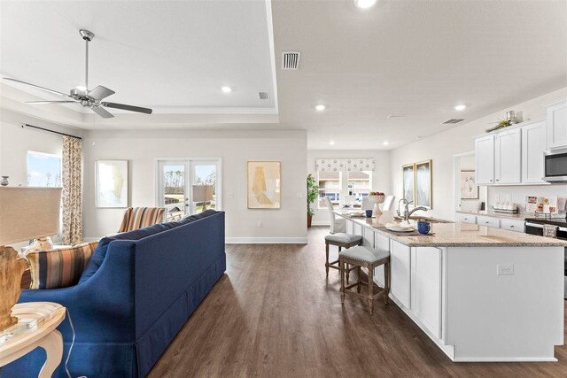 living room with ceiling fan, sink, dark hardwood / wood-style flooring, and ornamental molding