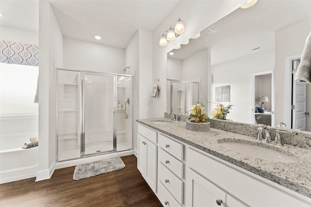 bathroom with shower with separate bathtub, vanity, and wood-type flooring