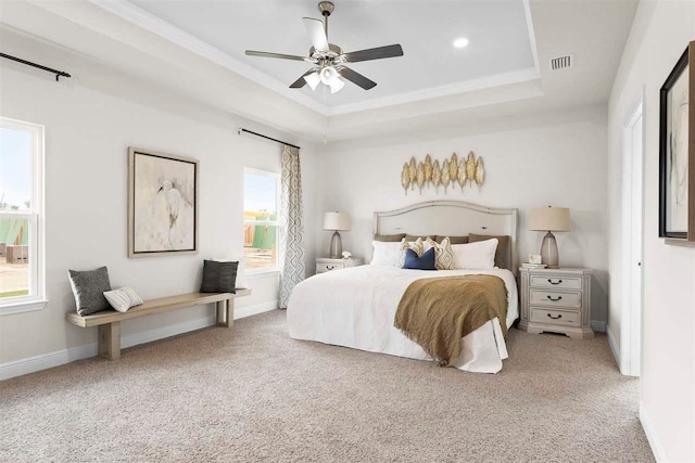 bedroom with a tray ceiling, ceiling fan, and carpet floors