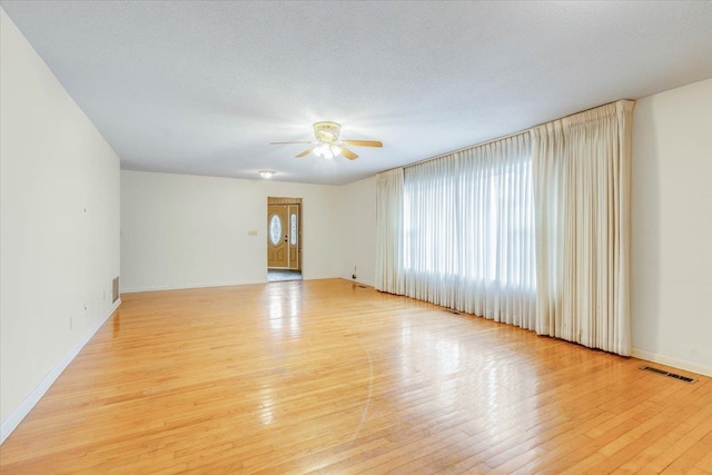 spare room featuring ceiling fan, a textured ceiling, and light wood-type flooring