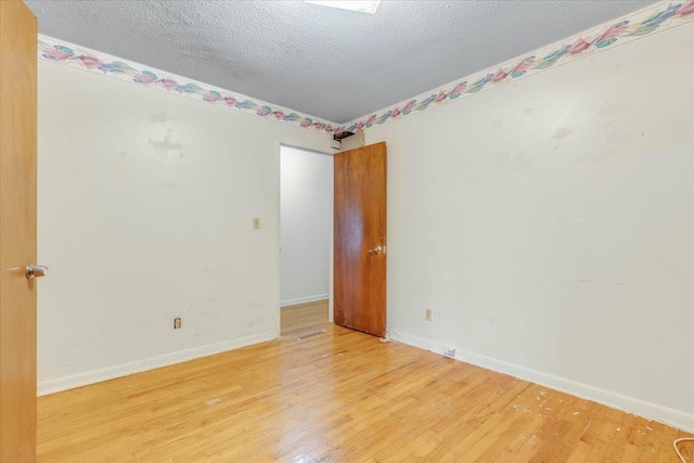 unfurnished room featuring hardwood / wood-style flooring and a textured ceiling