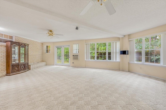 unfurnished living room featuring carpet flooring, a healthy amount of sunlight, and brick wall