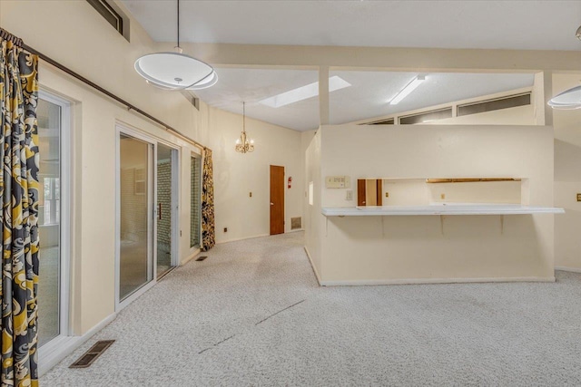 kitchen featuring pendant lighting, a notable chandelier, and carpet