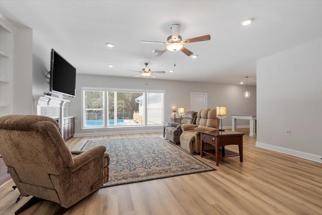 living room with ceiling fan and light hardwood / wood-style flooring