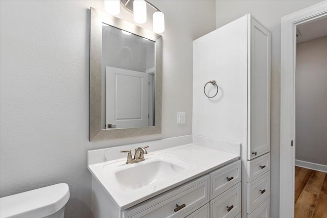 bathroom featuring vanity, toilet, and wood-type flooring