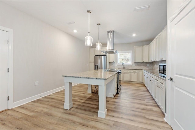 kitchen with appliances with stainless steel finishes, a kitchen breakfast bar, extractor fan, pendant lighting, and a center island