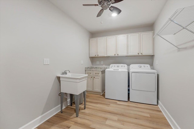 clothes washing area with cabinets, light hardwood / wood-style flooring, washer and clothes dryer, and ceiling fan