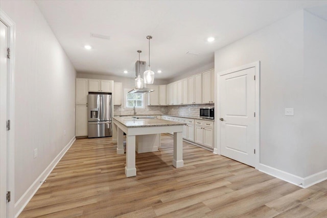 kitchen featuring a breakfast bar, hanging light fixtures, decorative backsplash, appliances with stainless steel finishes, and a kitchen island