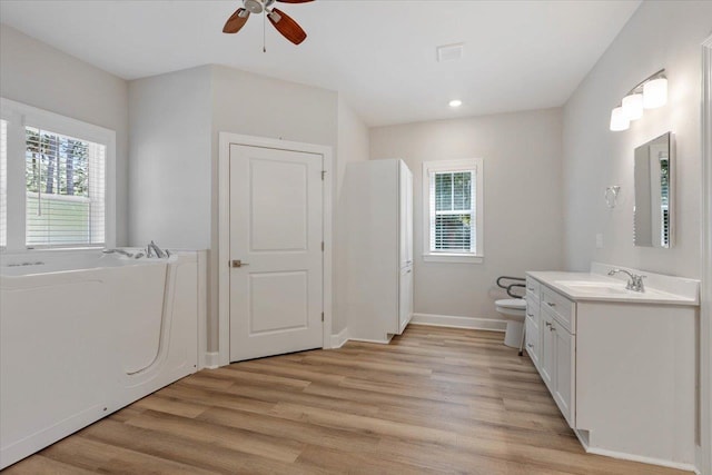 bathroom with vanity, toilet, wood-type flooring, and a wealth of natural light