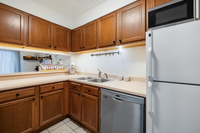 2020 Continental Ave Unit 144, Tallahassee, FL 32304 - kitchen with appliances with stainless steel finishes, a sink, light countertops, brown cabinets, and light tile patterned floors