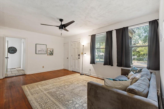 living room featuring a textured ceiling, dark hardwood / wood-style floors, and ceiling fan