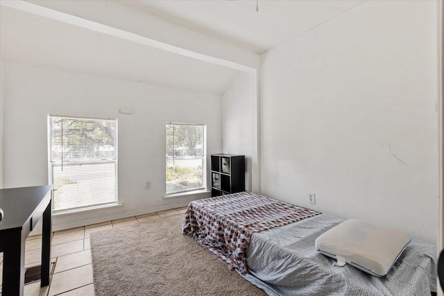 bedroom with light tile patterned floors and lofted ceiling