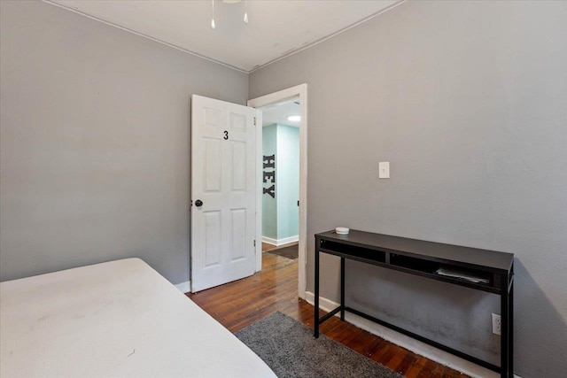 bedroom with dark hardwood / wood-style flooring