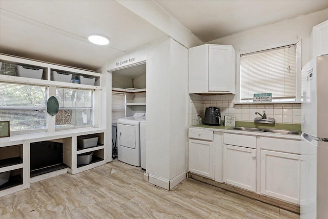 laundry room with light wood-type flooring, sink, and washing machine and clothes dryer