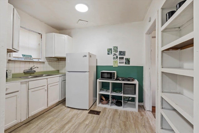 kitchen featuring white cabinetry, white refrigerator, sink, and light hardwood / wood-style flooring