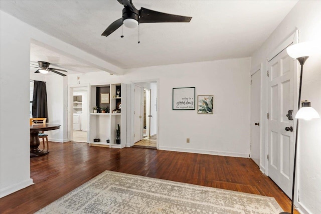 entryway featuring a textured ceiling, dark hardwood / wood-style floors, ceiling fan, washer / clothes dryer, and beam ceiling