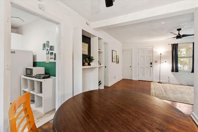 interior space with beam ceiling, ceiling fan, and hardwood / wood-style floors