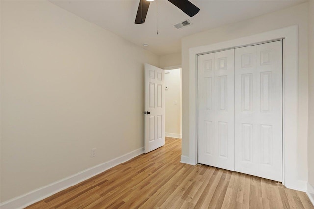 unfurnished bedroom featuring light hardwood / wood-style floors, ceiling fan, and a closet