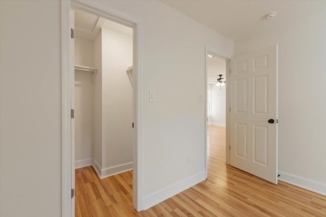 unfurnished bedroom with light hardwood / wood-style floors, a closet, and a walk in closet