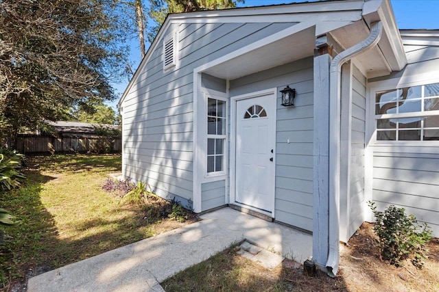 property entrance with a lawn