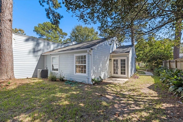 rear view of property with central AC, a lawn, and french doors