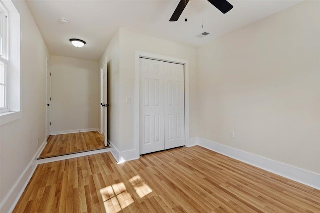 unfurnished bedroom with ceiling fan, a closet, and light hardwood / wood-style flooring